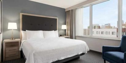 comfortable king bed with lots of natural light at Homewood Suites by Hilton University City Philadelphia, PA.