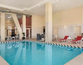 lovely indoor pool with surrounding seating area and sun beds at Homewood Suites by Hilton University City Philadelphia, PA.