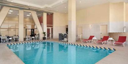 lovely indoor pool with surrounding seating area and sun beds at Homewood Suites by Hilton University City Philadelphia, PA.