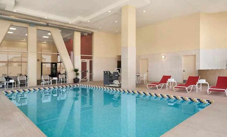 lovely indoor pool with surrounding seating area and sun beds at Homewood Suites by Hilton University City Philadelphia, PA.