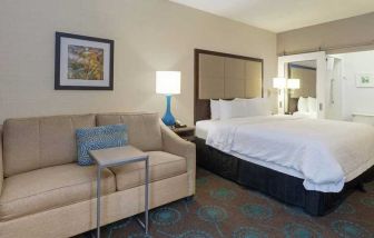 spacious king suite with comfortable lounge area at Hampton Inn Bloomington.