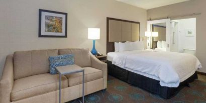 spacious king suite with comfortable lounge area at Hampton Inn Bloomington.