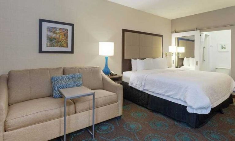 spacious king suite with comfortable lounge area at Hampton Inn Bloomington.