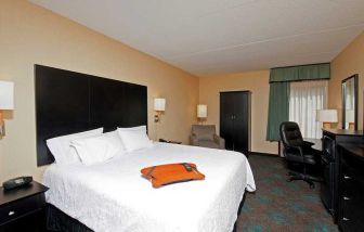 comfortable king room with TV and work desk at Hampton Inn Bloomington.