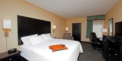 comfortable king room with TV and work desk at Hampton Inn Bloomington.