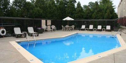 beautiful outdoor pool with seating area and sun beds at Hampton Inn Bloomington.