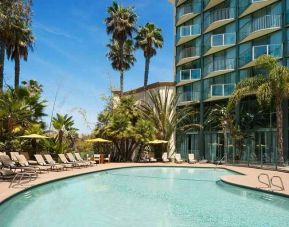 beautiful outdoor pool surrounded by greenery and with comfortable sun beds at DoubleTree by Hilton Hotel San Diego - Hotel Circle.