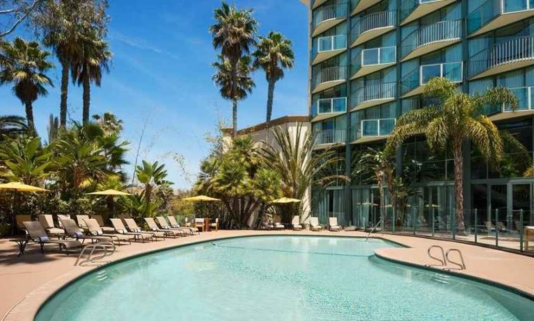 beautiful outdoor pool surrounded by greenery and with comfortable sun beds at DoubleTree by Hilton Hotel San Diego - Hotel Circle.