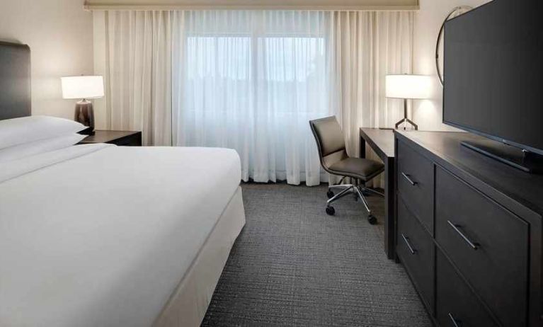 comfortable king room with TV and work desk ideal for working remotely at Embassy Suites by Hilton Detroit Troy Auburn Hills.