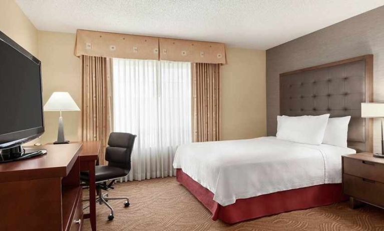 spacious king room with TV and work desk ideal for working remotely at Homewood Suites by Hilton Oakland-Waterfront.