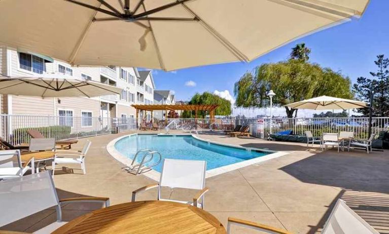 lovely outdoor pool with shaded seating area at Homewood Suites by Hilton Oakland-Waterfront.