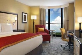 beautiful king suite with TV and work desk with lots of natural light at Hilton Rosemont/Chicago O'Hare.