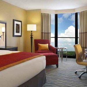 beautiful king suite with TV and work desk with lots of natural light at Hilton Rosemont/Chicago O'Hare.