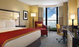 beautiful king suite with TV and work desk with lots of natural light at Hilton Rosemont/Chicago O'Hare.