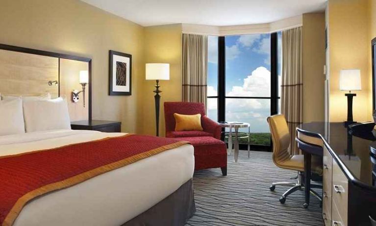 beautiful king suite with TV and work desk with lots of natural light at Hilton Rosemont/Chicago O'Hare.