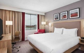 Bright king bedroom with desk and TV screen at the Hilton Garden Inn Dublin Custom House.