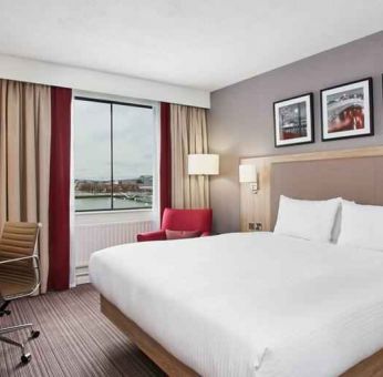 Bright king bedroom with desk and TV screen at the Hilton Garden Inn Dublin Custom House.