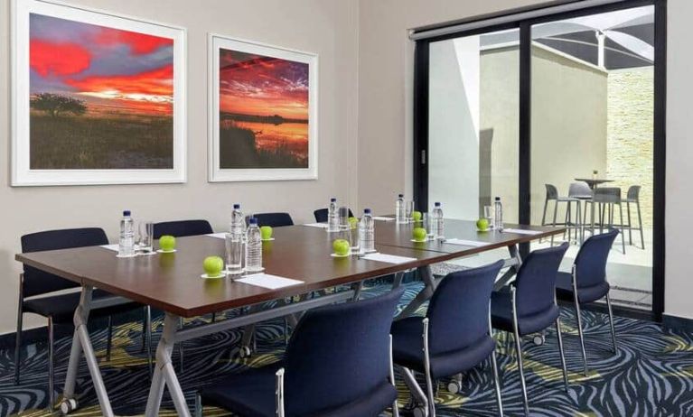 Small meeting room with rectangular table and seating for 8 guests.