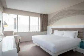 King bedroom with TV screen and desk at the Morrison, a DoubleTree by Hilton Hotel.