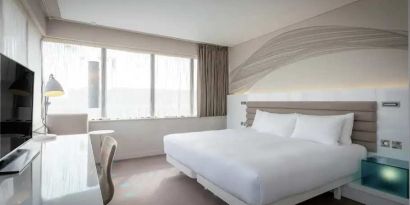 King bedroom with TV screen and desk at the Morrison, a DoubleTree by Hilton Hotel.