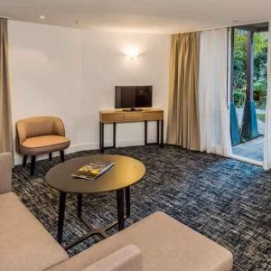 Suite living room with sofa and desk at the Morrison, a DoubleTree by Hilton Hotel.