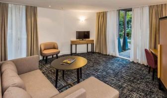 Suite living room with sofa and desk at the Morrison, a DoubleTree by Hilton Hotel.