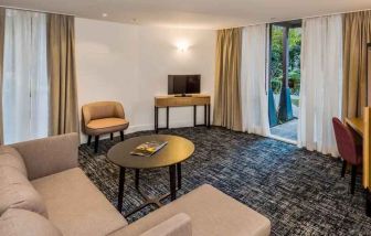 Suite living room with sofa and desk at the Morrison, a DoubleTree by Hilton Hotel.