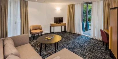 Suite living room with sofa and desk at the Morrison, a DoubleTree by Hilton Hotel.