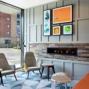 Lobby workspace by the fireplace at the Hampton by Hilton Belfast City Centre.