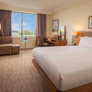 King bedroom with sofa, TV screen and desk at the Hilton Dublin Airport.