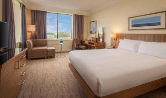 King bedroom with sofa, TV screen and desk at the Hilton Dublin Airport.