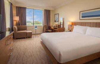 King bedroom with sofa, TV screen and desk at the Hilton Dublin Airport.