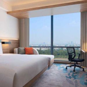 King bedroom with desk along the window at the Hilton Garden Inn Jakarta Taman Palem.