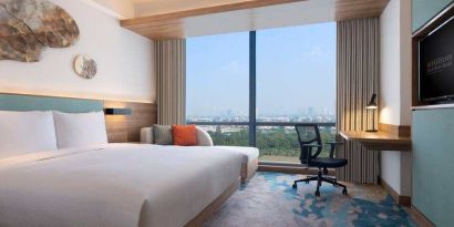 King bedroom with desk along the window at the Hilton Garden Inn Jakarta Taman Palem.