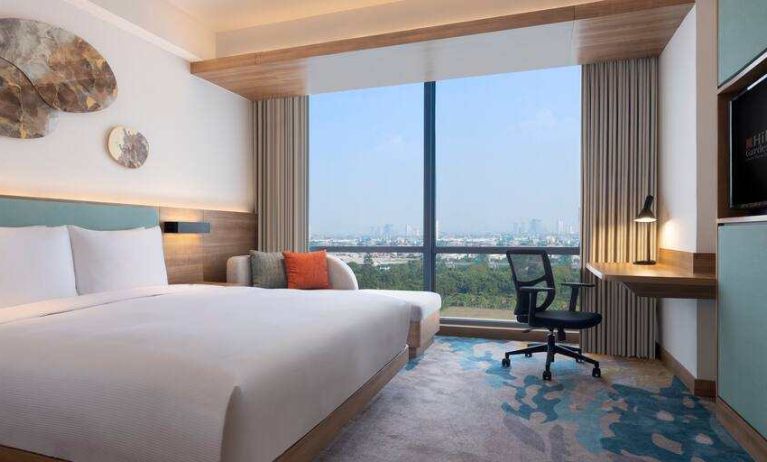 King bedroom with desk along the window at the Hilton Garden Inn Jakarta Taman Palem.