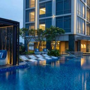 Beautiful outdoor pool area with lounges at the Hilton Garden Inn Jakarta Taman Palem.