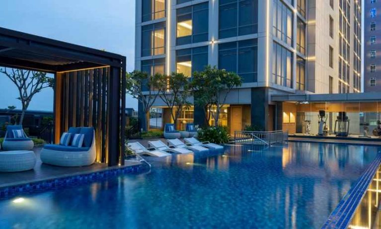 Beautiful outdoor pool area with lounges at the Hilton Garden Inn Jakarta Taman Palem.