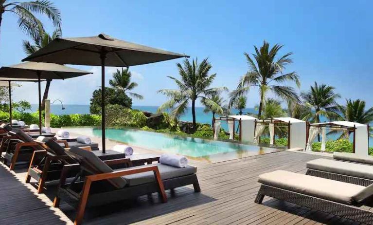 Outdoor pool with lounges at the Hilton Bali Resort.