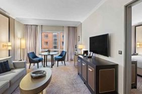 Spacious living room with working station by the window at the Hilton Munich City.