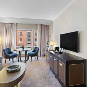 Spacious living room with working station by the window at the Hilton Munich City.