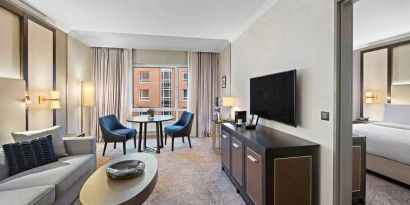 Spacious living room with working station by the window at the Hilton Munich City.