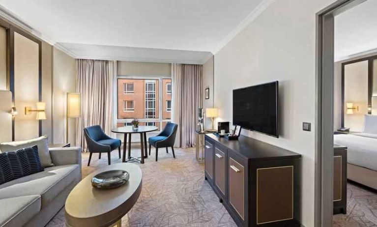 Spacious living room with working station by the window at the Hilton Munich City.