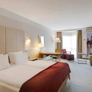 King bedroom with desk, sofa and TV screen at the DoubleTree by Hilton Hannover Schweizerhof.