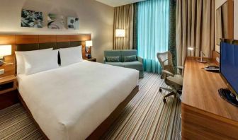 Queen room with desk and sofa at the Hilton Garden Inn Frankfurt Airport.