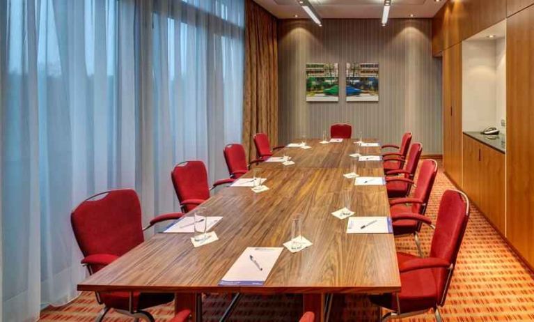 Meeting room with large windows at the Hilton Garden Inn Frankfurt Airport.