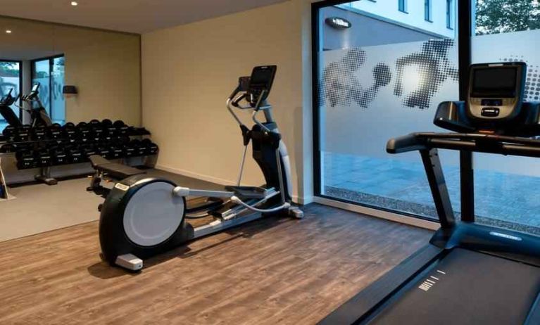 Fitness center with treadmill and machines at the Hampton by Hilton Kaiserslautern.