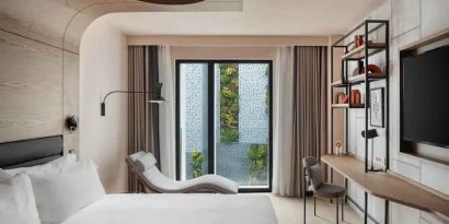 King guestroom with lounge and desk at the Canopy by Hilton Paris Trocadero.