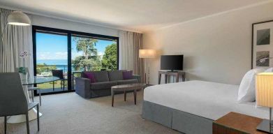 Hotel studio with sofa, TV screen and desk at the Hilton Evian-les-Bains.