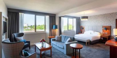 Spacious king suite with living room and working station at the Hilton Strasbourg.