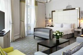 Spacious hotel suite with sofa and TV screen at the Hilton Paris Opera.